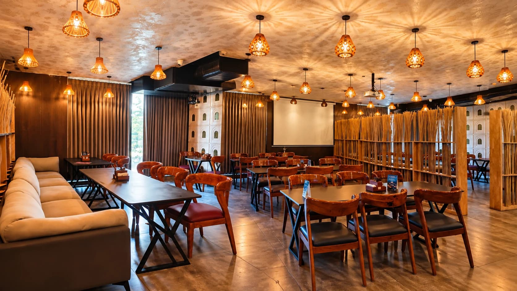 Dashami dining room with warm wooden lamps, set tables and a long sofa seat